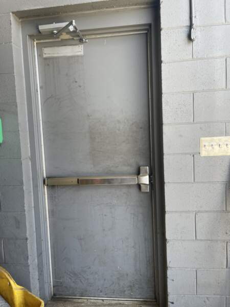 Broken Exit Panic Device requires immediate attention of a commercial door repair company to repair it and secure the site